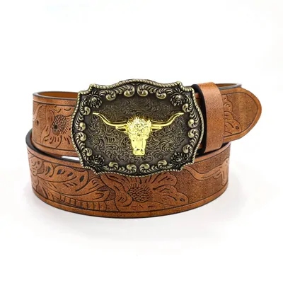 A tan tooled leather belt coiled on white, with a large antique gold buckle cast with a longhorn bull's head.