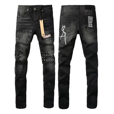 Two pairs of black distressed jeans laid out on white, the left studded across the knees and still tagged, the right marked with a block of small white text on the pocket.