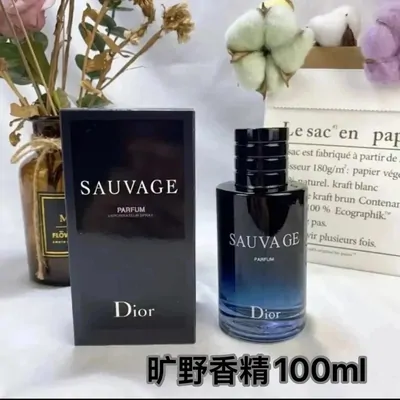 A dark navy fragrance bottle beside its black box on white cloth, with dried cotton stems behind it and a line of Chinese text burned into the lower left corner.